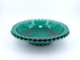 un bol vert posé sur une table blanche