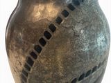 a metal vase with holes in it sitting on a table