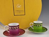 two cups and saucers in front of a yellow box