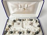 un bracelet de perles blanches et noires dans un coffret bleu