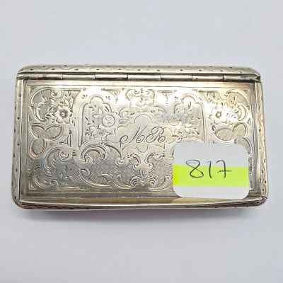 un vieux étui à cigarettes en argent sur lequel est collé un autocollant