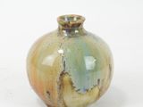 a small vase that is sitting on a white surface