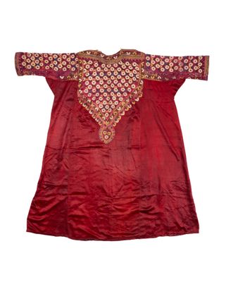a red silk tunic with a gold and red design on the chest