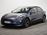 a grey tesla suv parked in a room with checkered floor