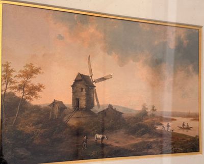 un tableau représentant un moulin à vent accroché au mur d'une pièce