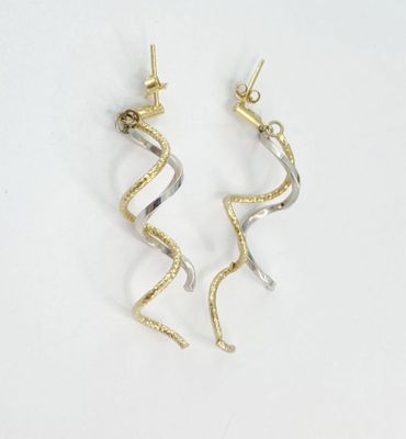 une paire de boucles d'oreilles en or et en argent sur fond blanc