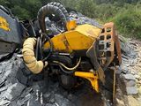 une machine jaune posée sur un tas de pierres