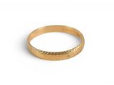 gros plan d'une bague en or sur une surface blanche