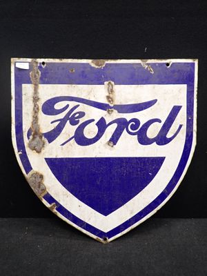 un ancien écusson Ford bleu et blanc sur fond noir