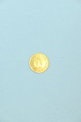 une pièce d'or posée sur une surface bleue