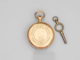 an antique gold pocket watch with a key attached to it
