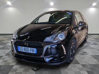 la voiture noire est garée sur un sol en damier dans le garage