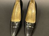 a pair of women ' s black shoes on a gray surface