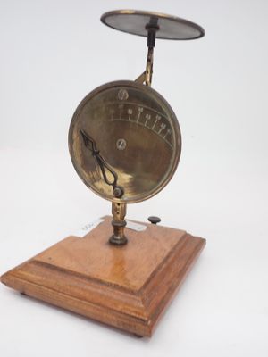une horloge posée sur un socle en bois, sur une surface blanche