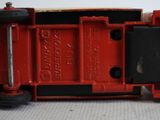 a close up of a red toy truck on a white surface