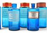 several blue bottles with labels are lined up on a white surface