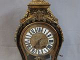 a gold clock with a statue on top of it