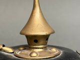 a black and gold vase with a gold top on a table