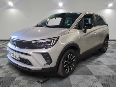 Un SUV blanc est garé dans une pièce dont le sol est en damier.