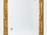 une image d'un miroir encadré d'or sur un mur blanc