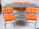 four orange chairs sitting at a table with a glass top
