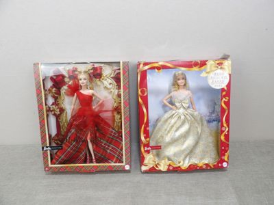 deux poupées dans leur boîte représentant une femme en robe rouge et une femme en robe blanche