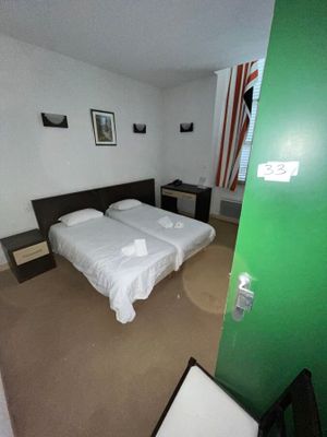 deux lits dans une chambre dont la porte est verte