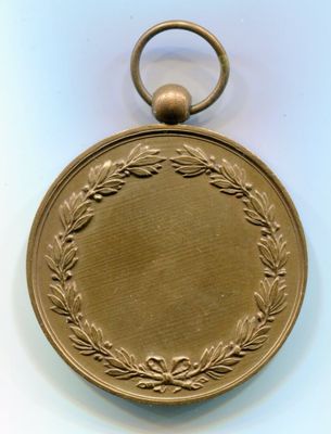 médaille d'or ornée d'une couronne de feuilles et d'un anneau sur fond blanc