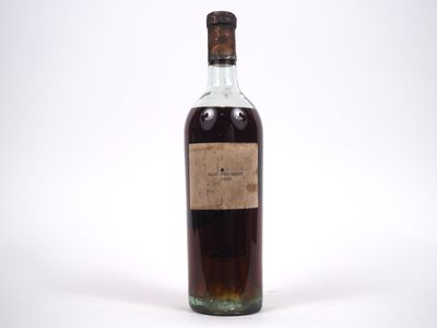une vieille bouteille d'alcool posée sur une surface blanche