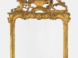 un miroir richement sculpté, orné d'un motif représentant un oiseau et un poisson