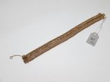 a close up of a gold bracelet with a tag on it