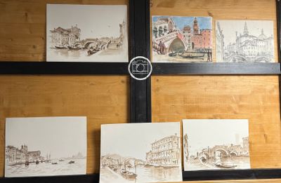 quatre tableaux accrochés au mur d'une pièce où se trouve une horloge murale