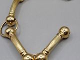 a close up of a gold bracelet on a gray surface