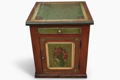 a small wooden cabinet with a painting on it