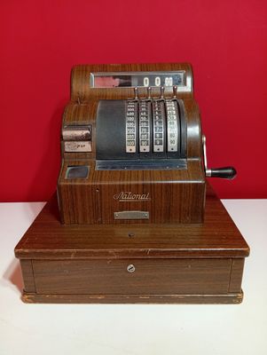 une caisse enregistreuse à l'ancienne posée sur une caisse en bois