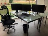 a glass desk with two computer monitors on it
