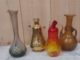 quatre vases de couleurs différentes posés sur une table