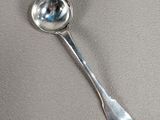 une cuillère en argent avec un manche de cuillère sur une table