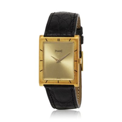 a close up of a gold watch with a black leather strap