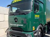 un gros camion vert garé sur un parking