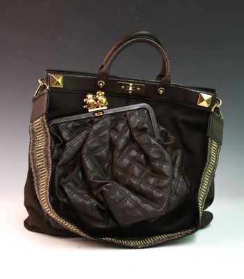 sac à main en cuir marron avec des fermetures éclair et des finitions dorées sur fond gris