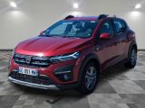 La voiture rouge est garée dans une grande pièce au sol en damier.