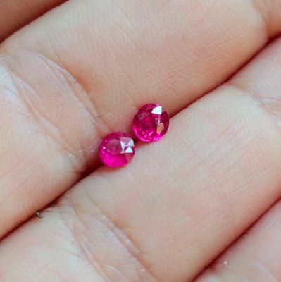 quelqu'un tient dans sa main une paire de saphirs roses