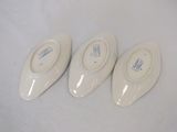 three pairs of white shoes sitting on top of a white surface