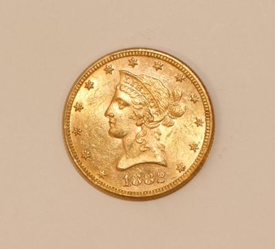 a close up of a gold coin with a woman ' s head on it