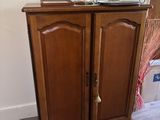 a wooden cabinet with a mirror on top of it