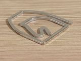 a metal object on a wooden surface that has a letter n in it