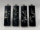 trois vases en noir et blanc ornés de fleurs, posés sur une surface blanche