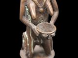 bronze figurine of a man holding a bowl on a black background