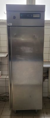 a stainless steel refrigerator in a kitchen with tile flooring